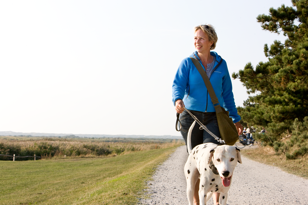 vrouw wandelt buiten met hond