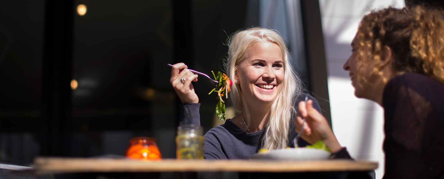 Vrouwen eten salade op terras