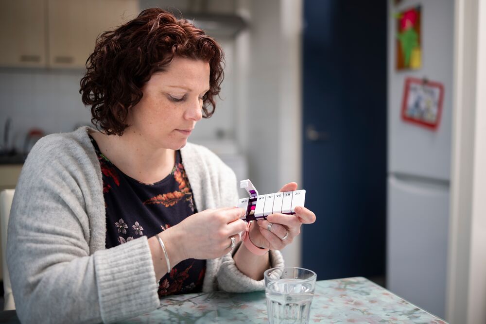 Vrouw houdt medicijnendoosje vast