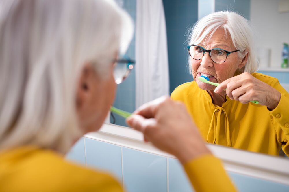 Vrouw poetst tanden in de spiegel