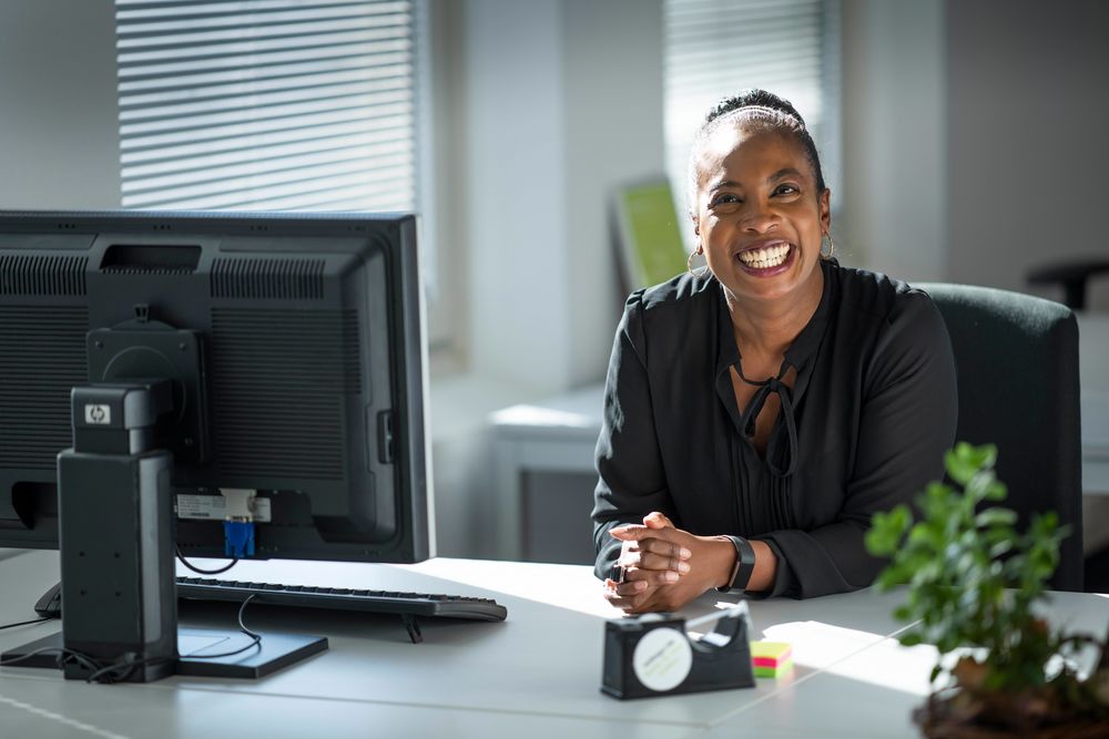 Vrouw achter bureau blij