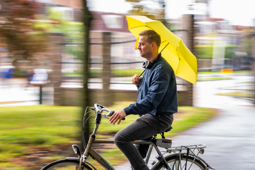 Man op fiets met paraplu