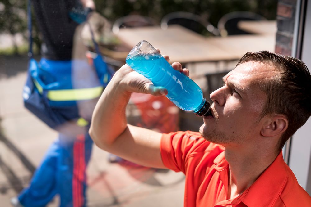 man drinkt uit bidon