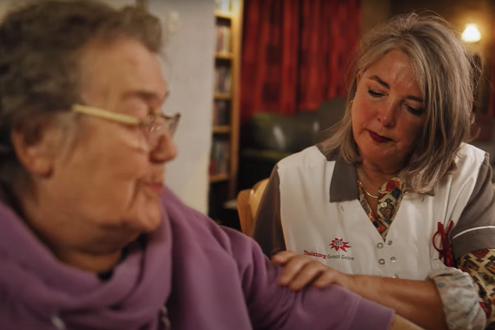 Wijkverpleegkundige helpt oude vrouw